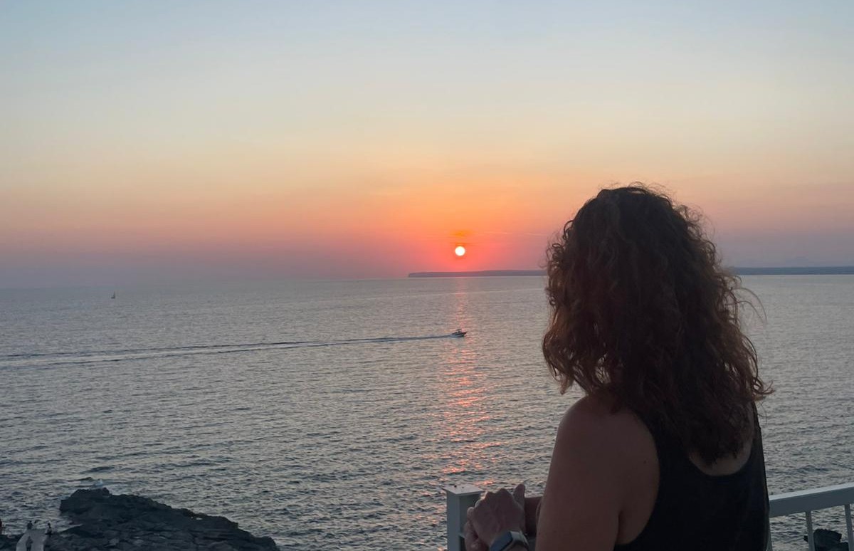 Silhouette face à la mer au coucher du soleil, atmosphère calme et contemplative.